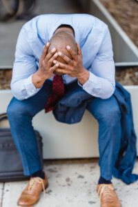 a man sits with head in hands