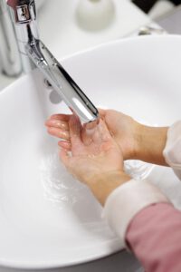 a medical worker washes her hands in a sink