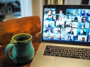 A laptop shows a zoom meeting in progress.