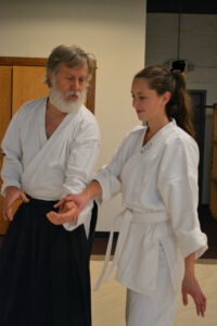 two people wearing martial arts uniforms move together