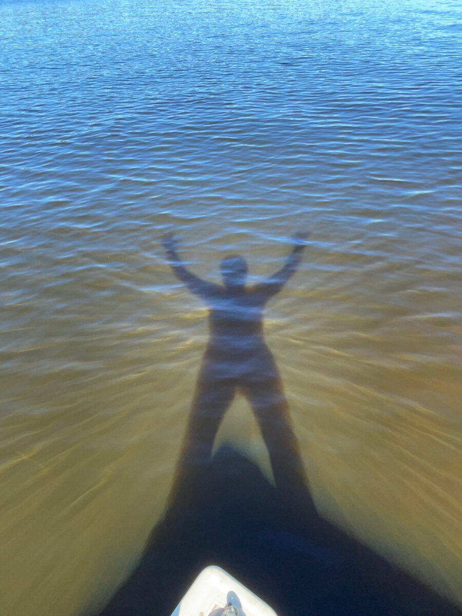 A shadow of a person standing over a lake