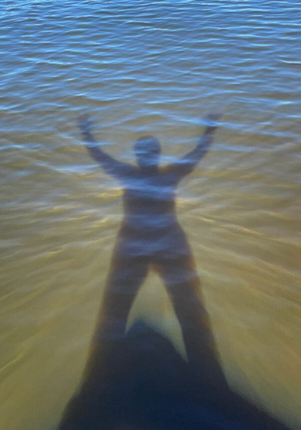 A shadow of a person standing over a lake