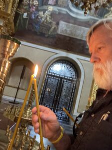 Daniel lights a candle in the cathedral.