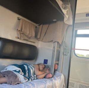 A child sleeps in a train cabin.